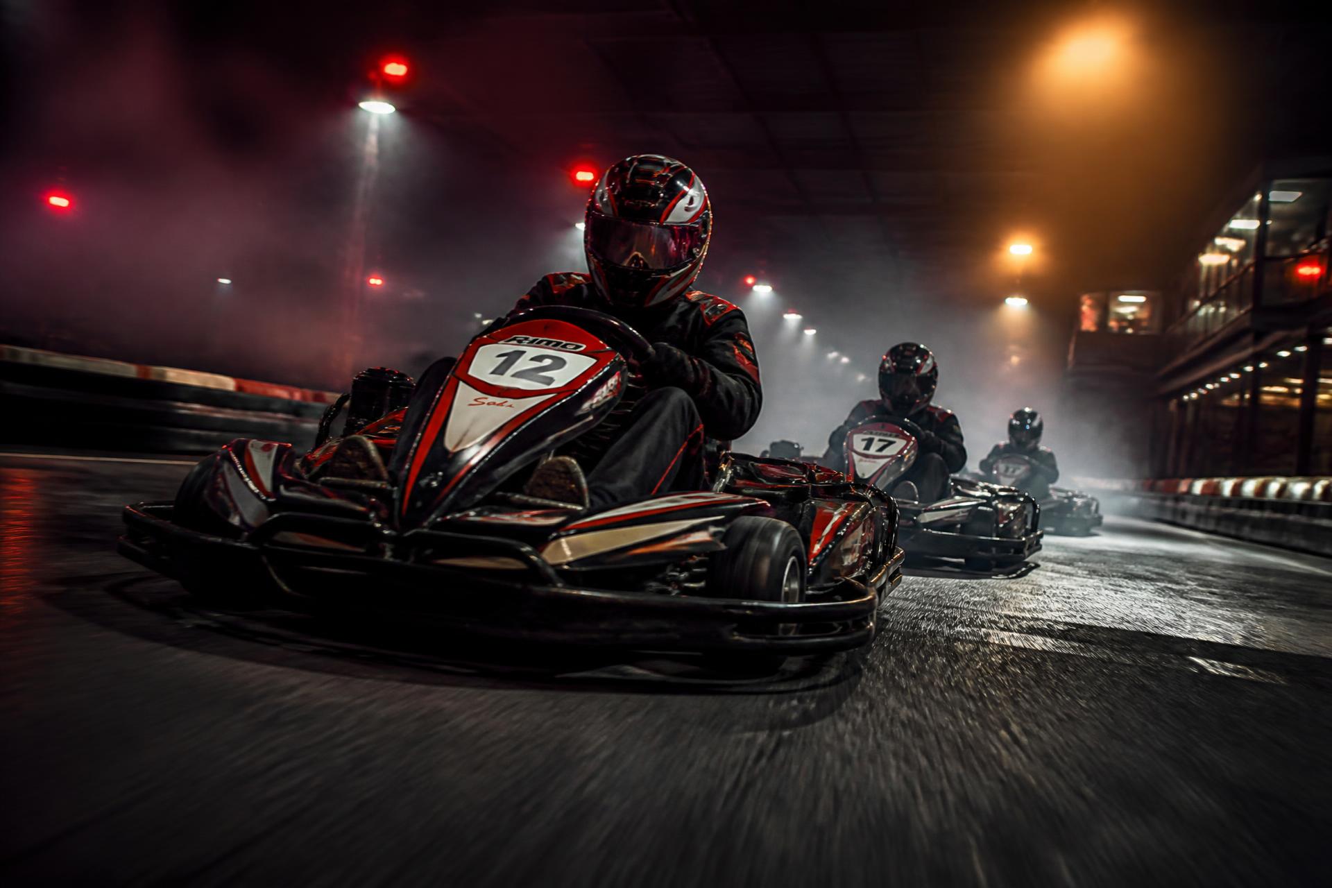 Go-karts racing under floodlights on the Apex Karting indoor circuit